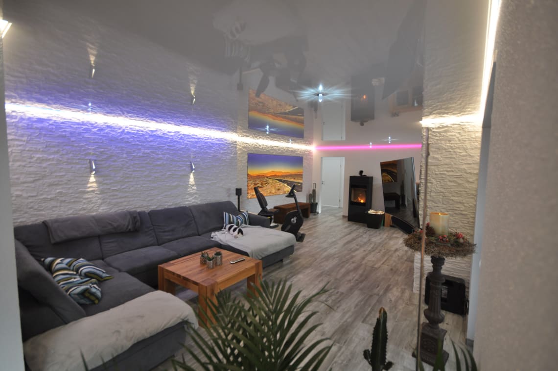 wohnzimmer_lackspanndecke_weiss_hochglanz_led_ledband_pendelleuchte_rgb_swarovski_sternenhimmel_wandbild_bedruckt_spanndecke Lackspanndecke Wohnzimmer LEDband
