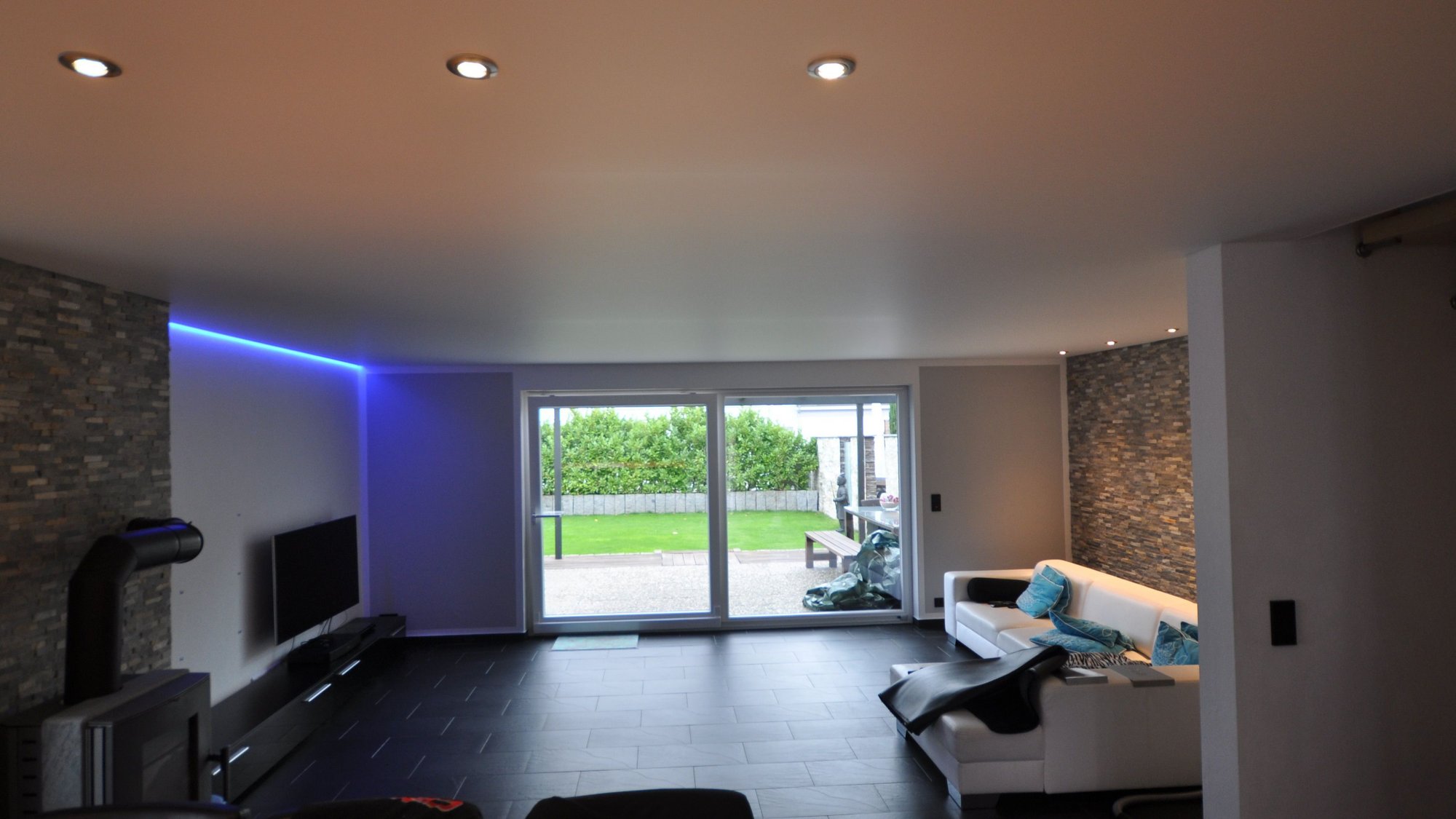 wohnzimmer_spanndecke_weiss_matt_led_einbaustrahler_ledband_rgb_steinwand Spanndecke Wohnzimmer RGB
