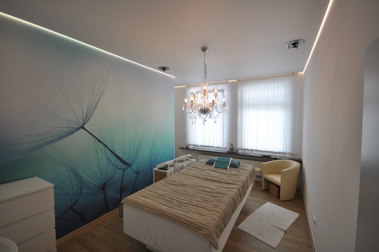 praxis_naturheil_lackspanndecke_spanndecke_weiss_matt_ledband_pendelleuchte_warmweiss_sonderprofil_deckenleuchte_deckenfeld_arbeitsplatzbeleuchtung_wandbild_bedruckt_rgb_4 Spanndecke Naturheilpraxis LEDband Kronleuchter