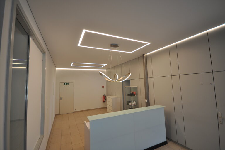 praxis_naturheil_lackspanndecke_spanndecke_weiss_matt_led_ledband_pendelleuchte_warmweiss_sonderprofil_deckenleuchte_deckenfeld_arbeitsplatzbeleuchtng_wandbild_bedruckt_rgb1 Spanndecke Naturheilpraxis LEDband Deckenfeld