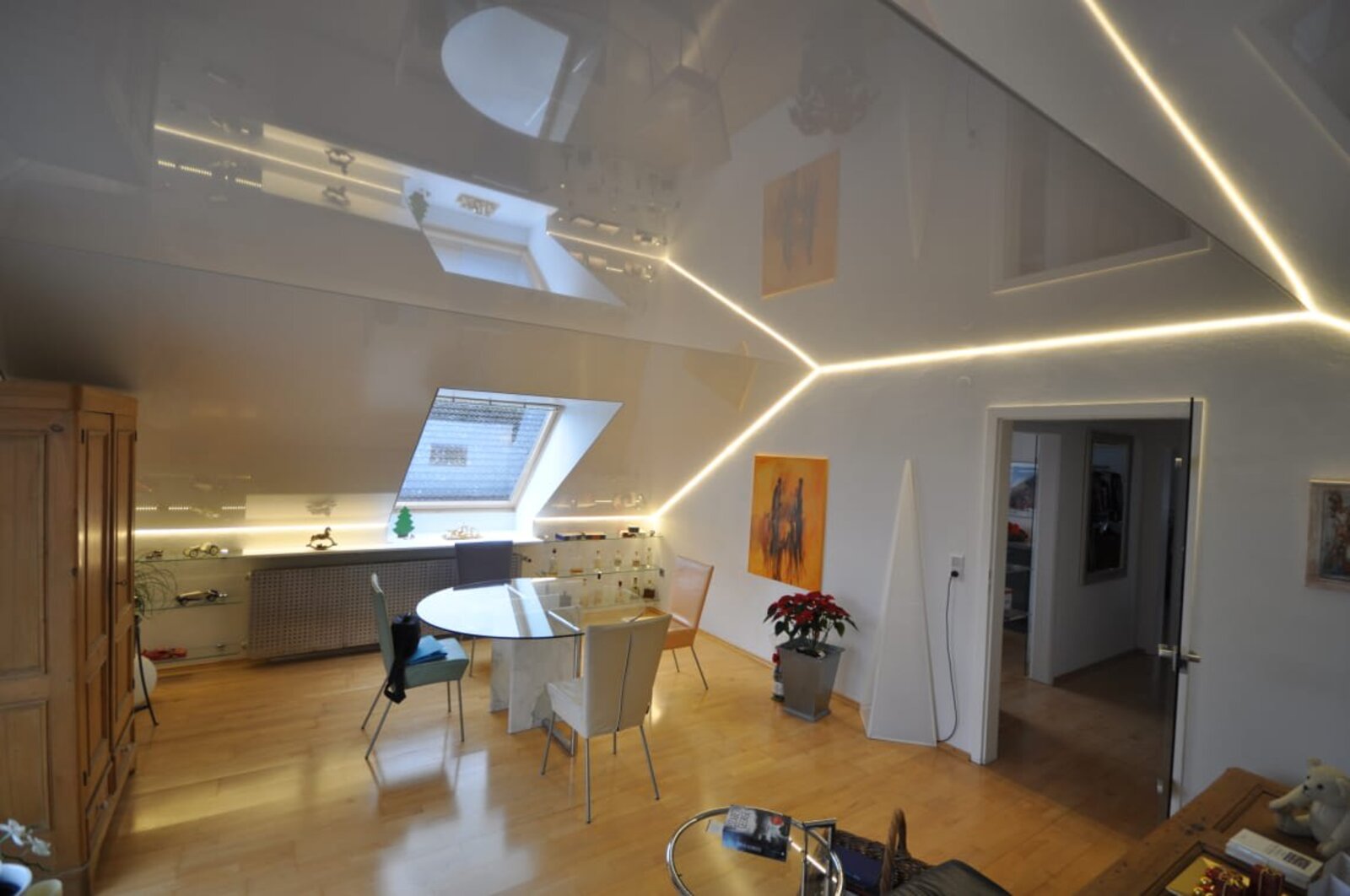 Lackspanndecke in weiss Hochglanz im Wohnzimmer mit Dachschräge, Beleuchtung mit LED-Lichtkanal in der Schattenfuge getrennt dimmbar