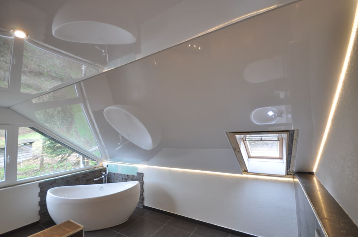 Lackspanndecke im Bad mit Dachschräge in weiss Hochglanz, Beleuchtung mit LED-Einbaustrahlen und LED Lichtkanal in der Schattenfuge 