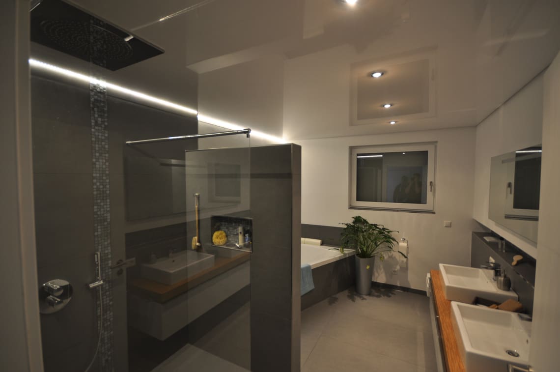 Lackspanndecke im Bad in weiss Hochglanz mit LED-Einbaustrahlern und LED Lichtkanal in der Schattenfuge dimmbar