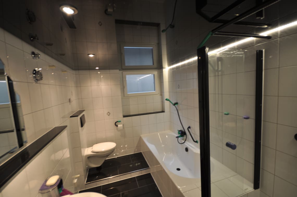 Lackspanndecke im Bad in schwarz Hochglanz, Beleuchtung mit LED-Einbaustrahlern und LED-Lichtkanal in der Schattenfuge dimmbar