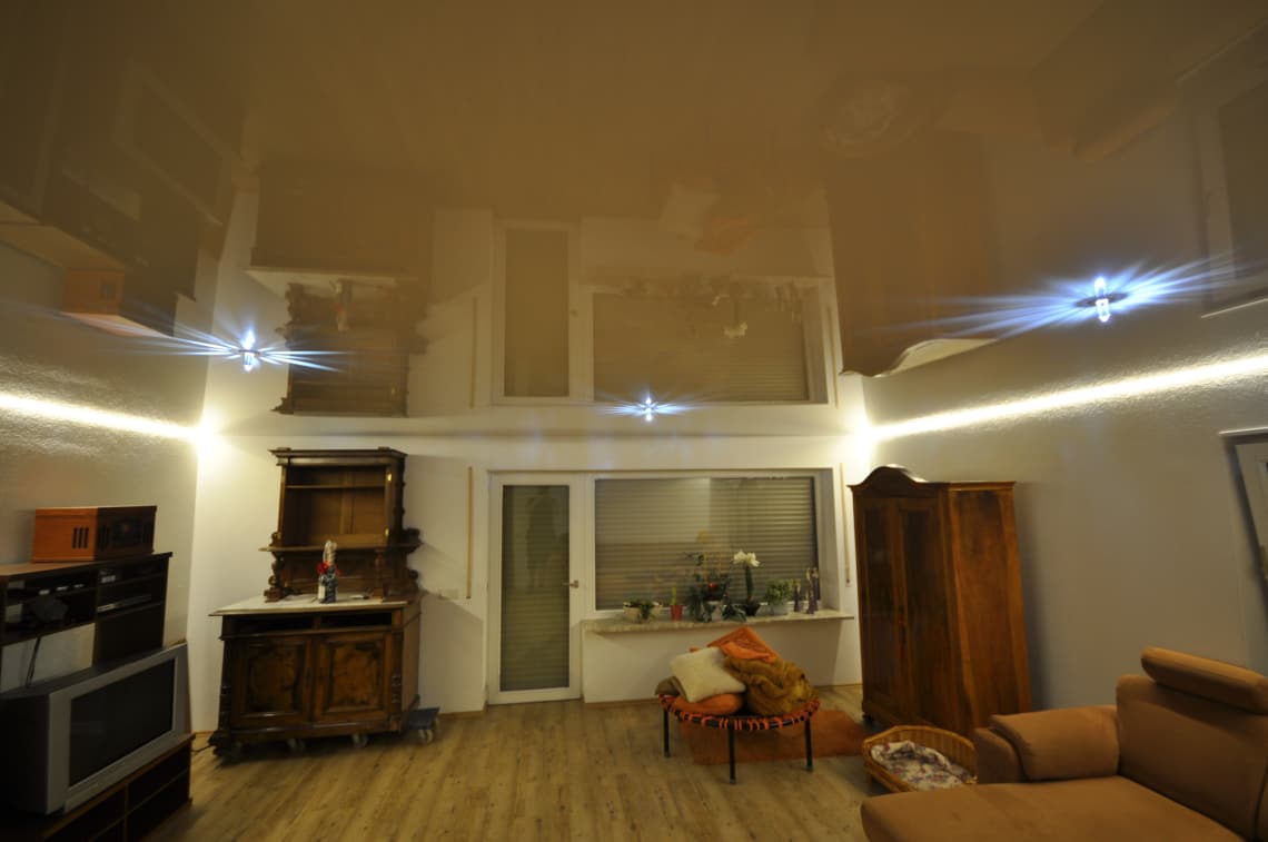 Lackspanndecke weiß Hochglanz im Wohnzimmer mit LED-Lichtkanal in der Schattenfuge getrennt dimmbar und Swarovski Sternenhimmel