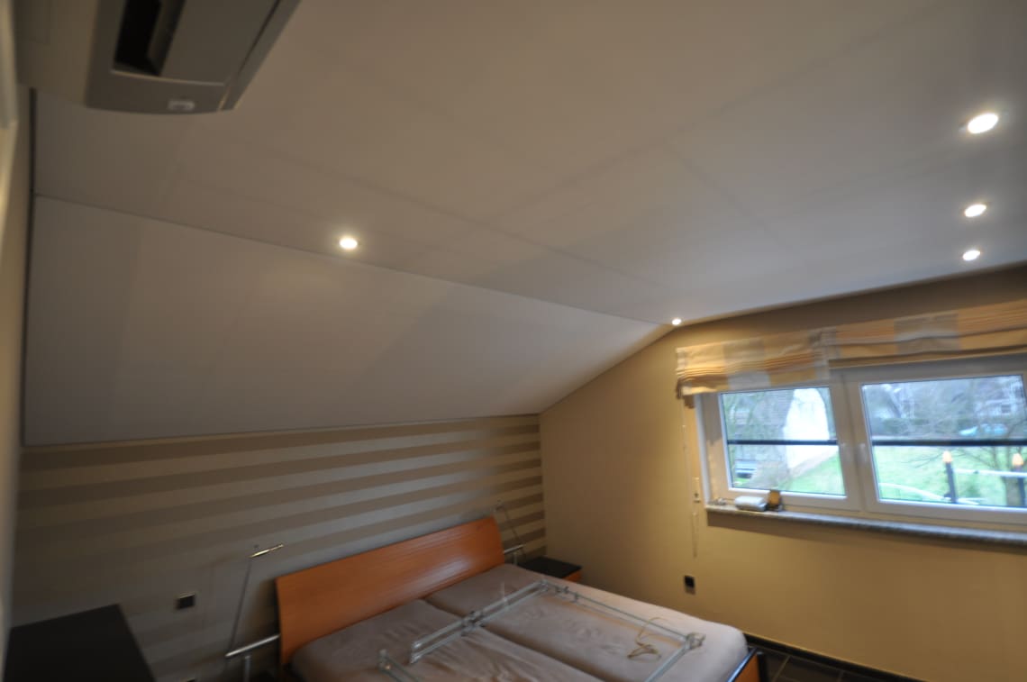 Spanndecke im Schlafzimmer mit Dachschräe in weiss matt. Beleuchtung mit LED-Einbaustrahlern