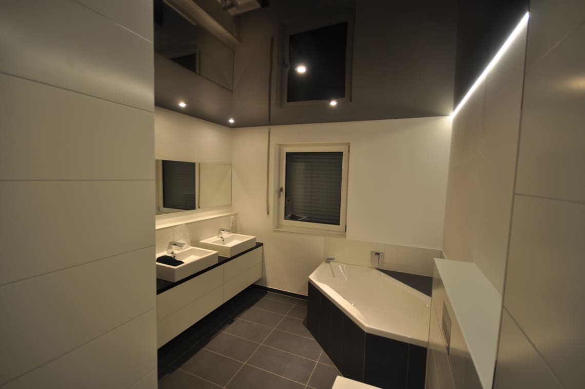 Lackspanndecke im Bad in schwarz Hochglanz mit LED Einbaustrahler und LED-Lichtkanal in der Schattenfuge dimmbar 
