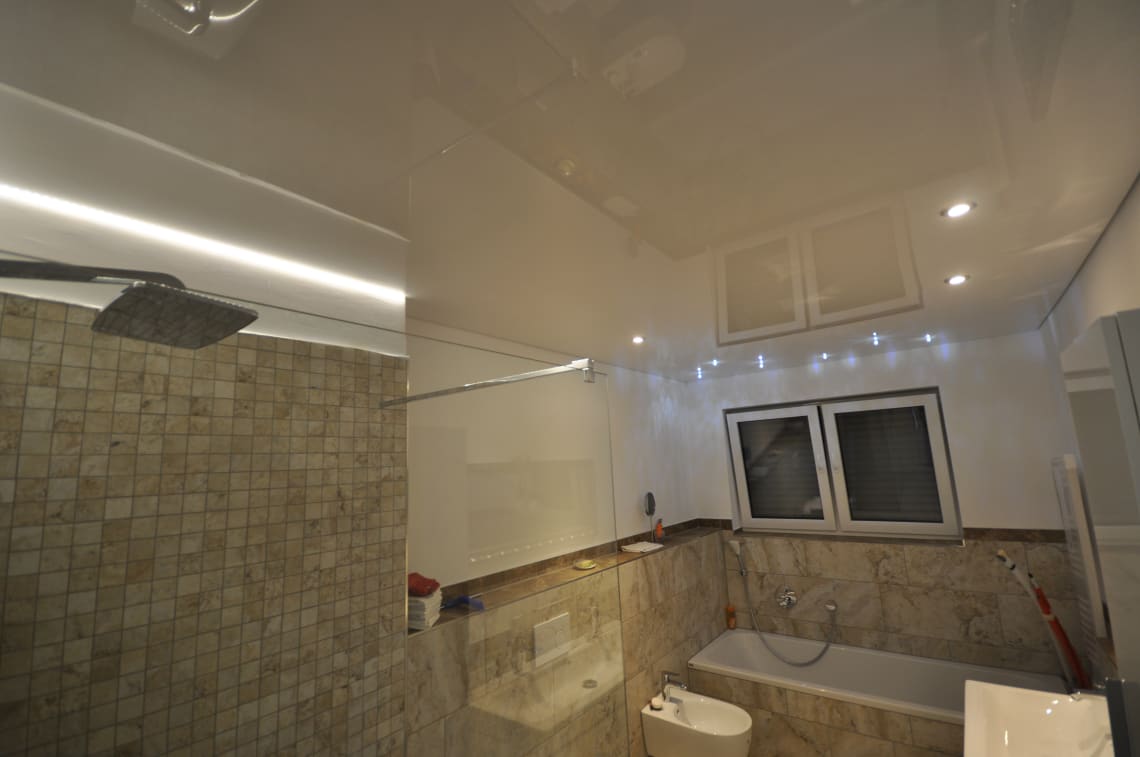 Lackspanndecke im Bad in weiss Hochglanz, Beleuchtung mit LED-Einbaustahlern, LED-Lichtkanal in der Schattenfuge und Swarovski Sternenhimmel über der Badewanne